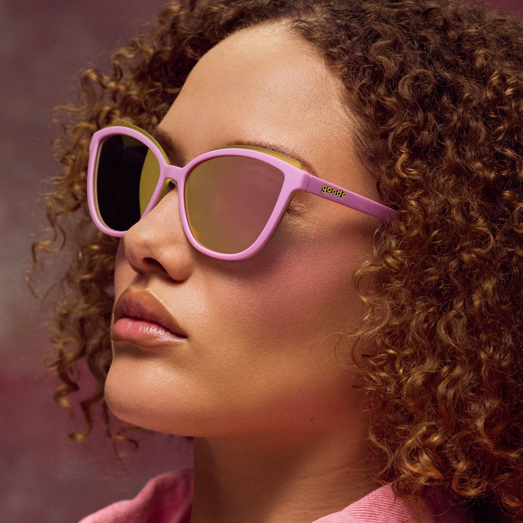 Woman wearing pink sunglasses with a blurred background