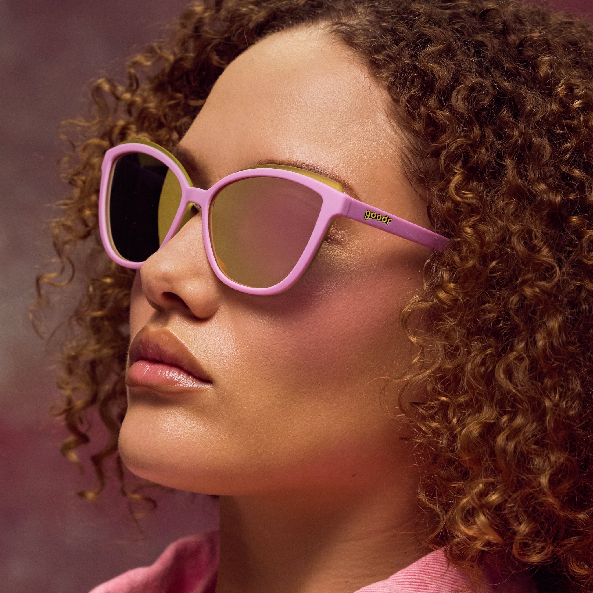 Woman wearing pink sunglasses with a blurred background