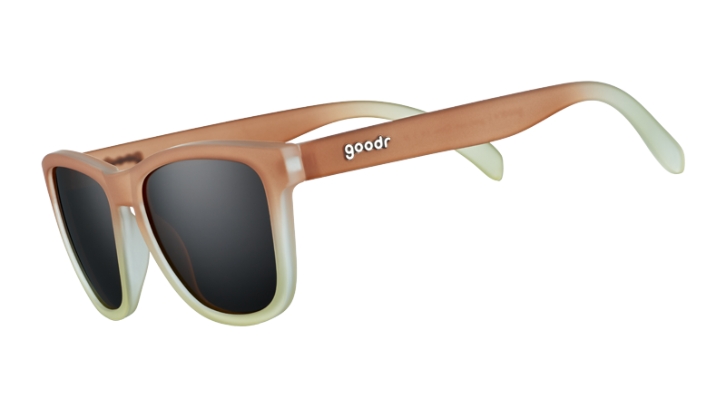 Three-quarter angle view of square-shaped sunglasses with brown-to-white gradient frames and brown, non-reflective lenses.