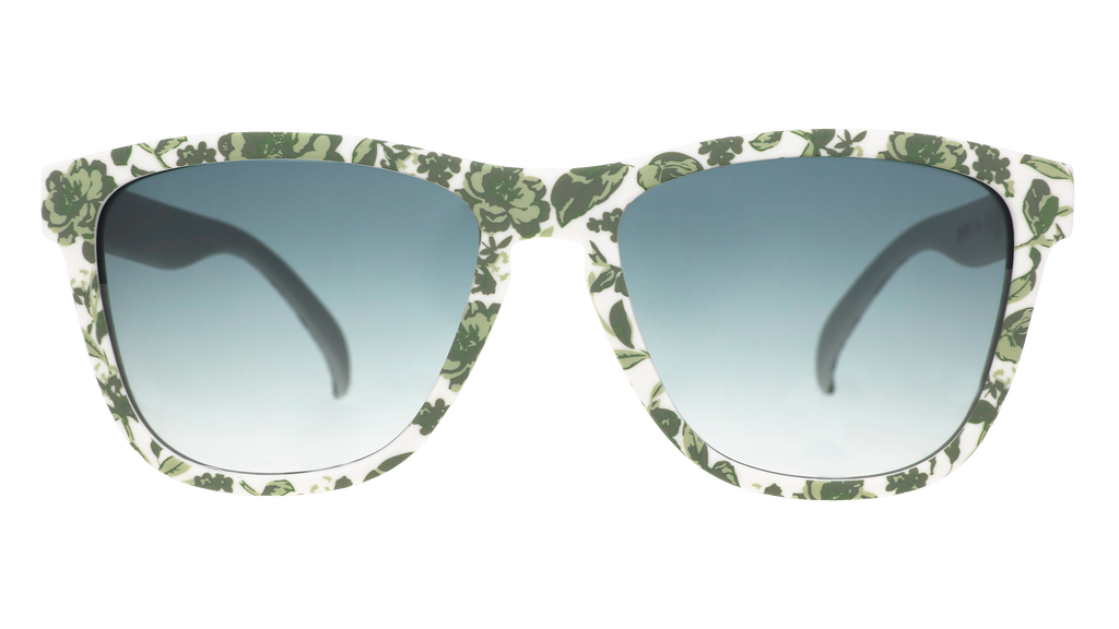 Front view of sunglasses with a green and white floral toile and green gradient lenses.