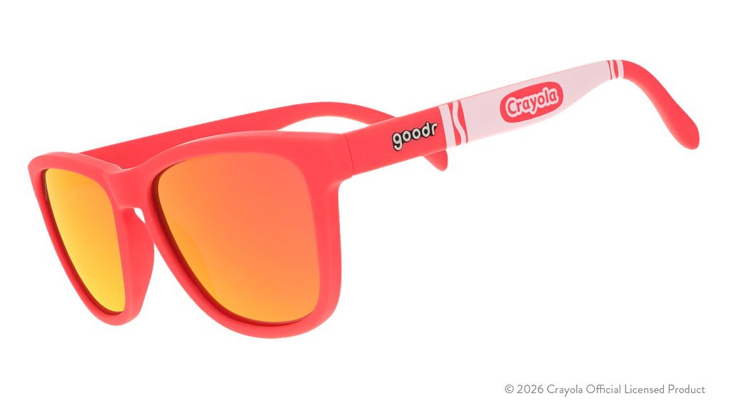 Three-quarter angle view of coral sunglasses w/ white Crayola marker pattern+burnt orange reflective lenses tilted down.