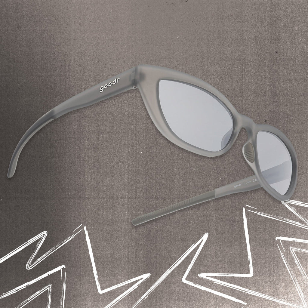 Three-quarter angle view of gray cat eye shades with chrome lenses tilted up on a gray background.