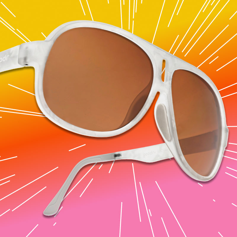 Front view of aviator sunglasses with a translucent white frame and brown non-reflective lenses.