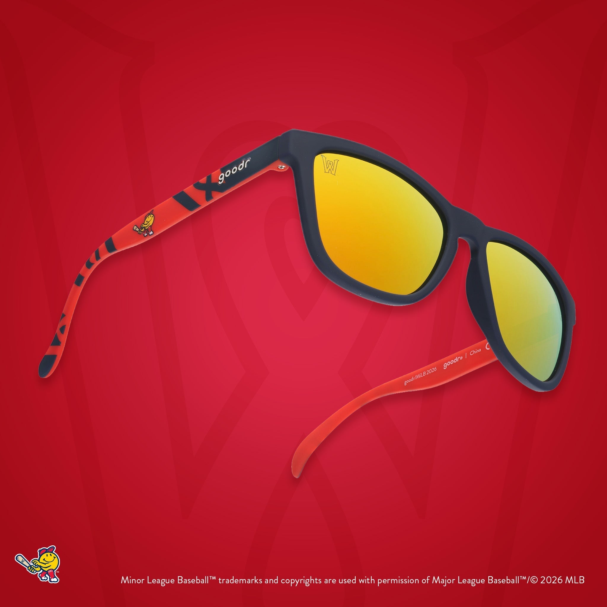 Three-quarter angle view of shades. Dark blue frames w/ a red pattern, WooSox logo on temples + amber reflective lenses.