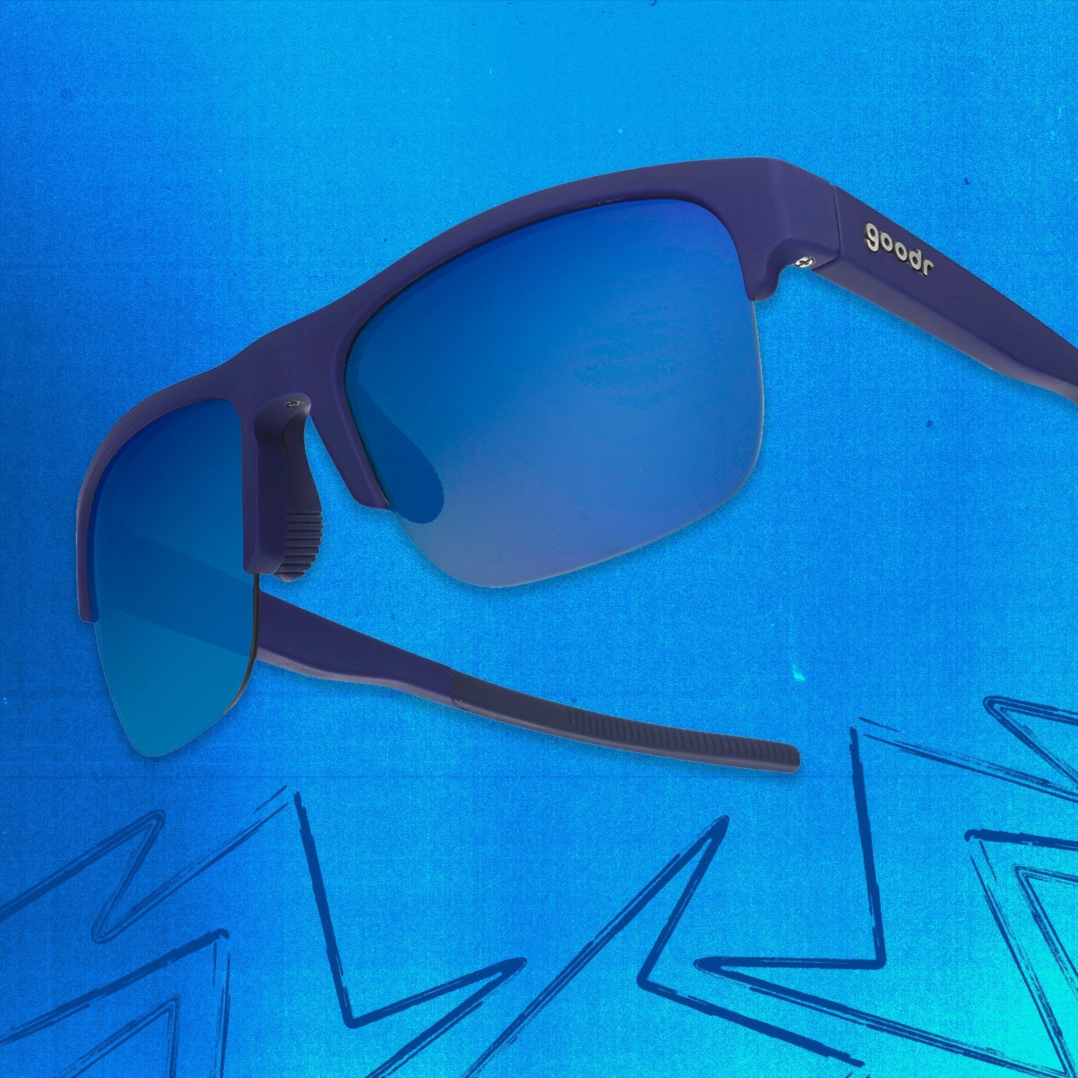 Three-quarter angle view of navy blue shades w/ half-rim frames+blue gradient lenses tilted up on a blue background.