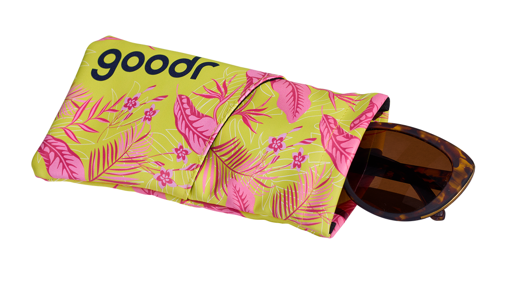 Three-quarter angle view of a soft fabric sunglasses case featuring a tropical design. A pair of tortoiseshell shades is shown partially pulled out.