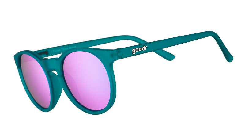 Three-quarter angle view of round teal sunglasses with reflective purple circle-shaped lenses.