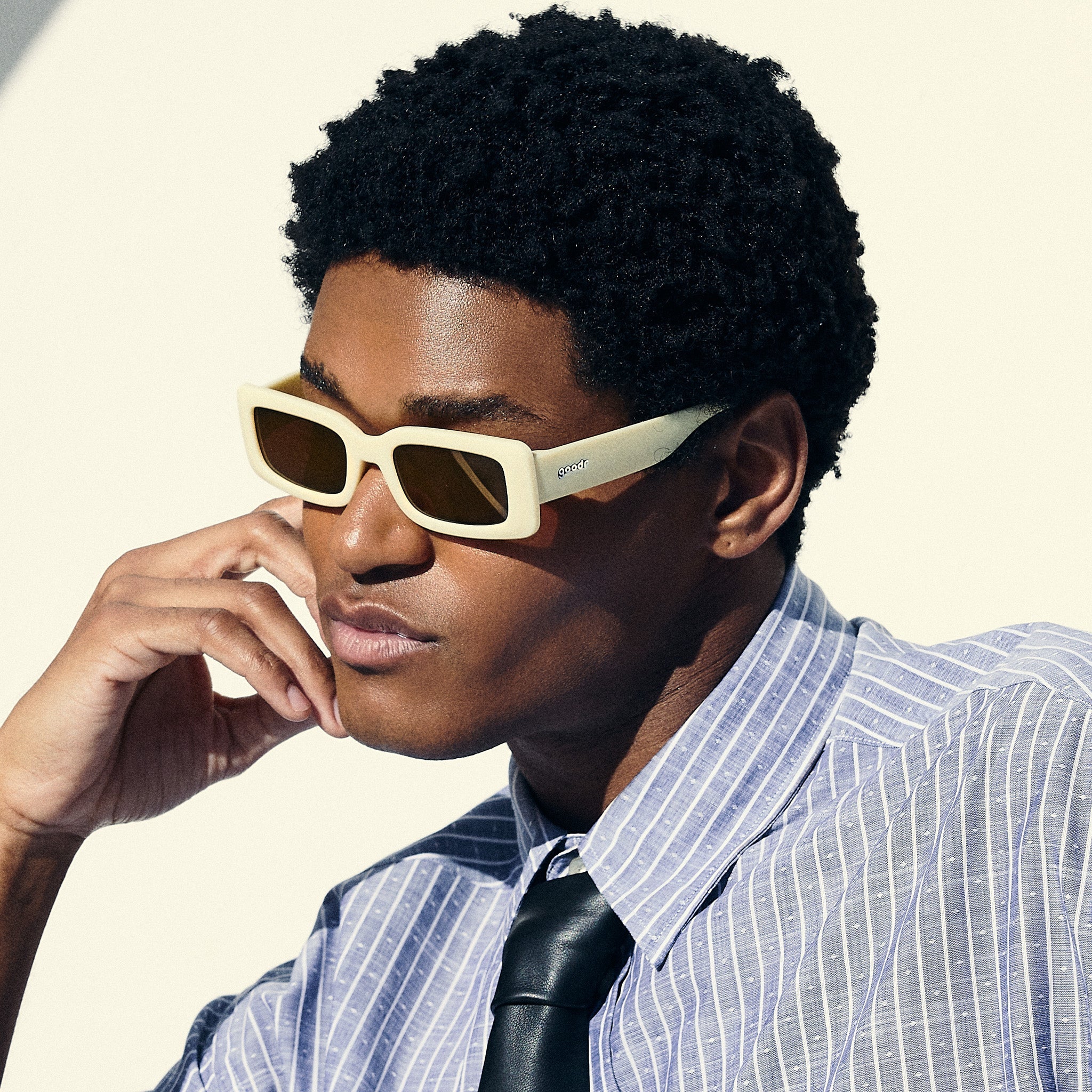 A man poses, wearing yellow rectangular sunglasses with brown-tinted polarized lenses.
