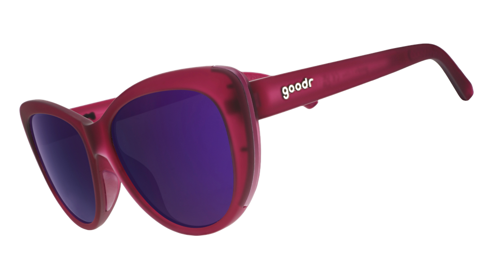 Three-quarter angle view of translucent purple cat-eye sunglasses with purple reflective lenses.
