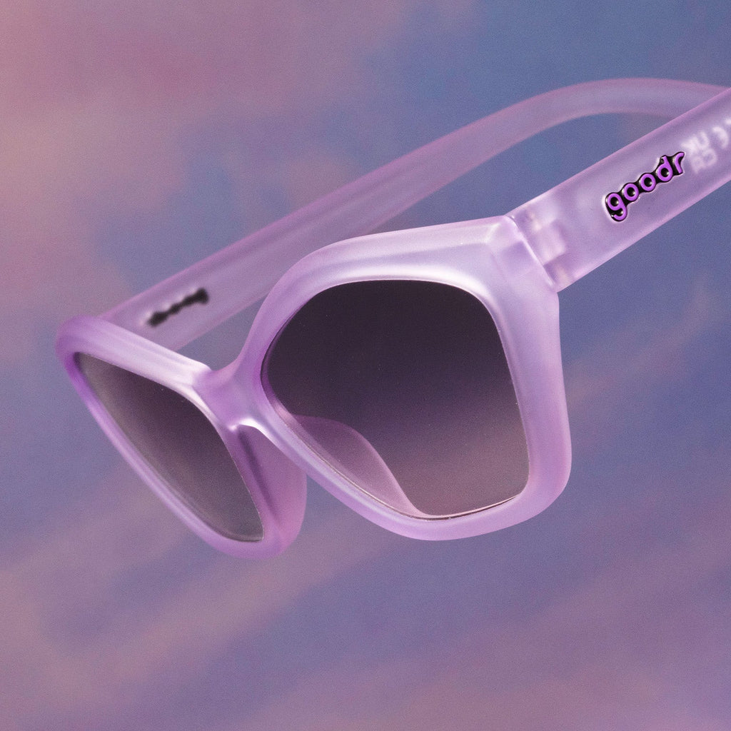 Three-quarter angle view of translucent pale purple geometric cat-eye Deco Gs floating against a purplish pink backdrop.