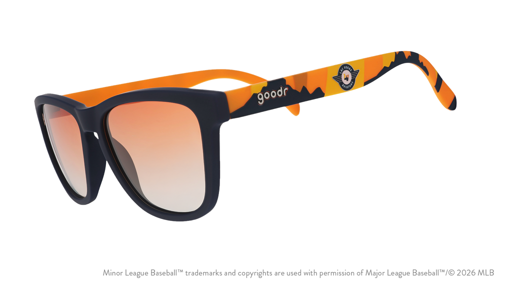 Angled view of shades tilted down. Blue frames w/ an orange+yellow landscape, Aviators logo+orange gold gradient lenses.