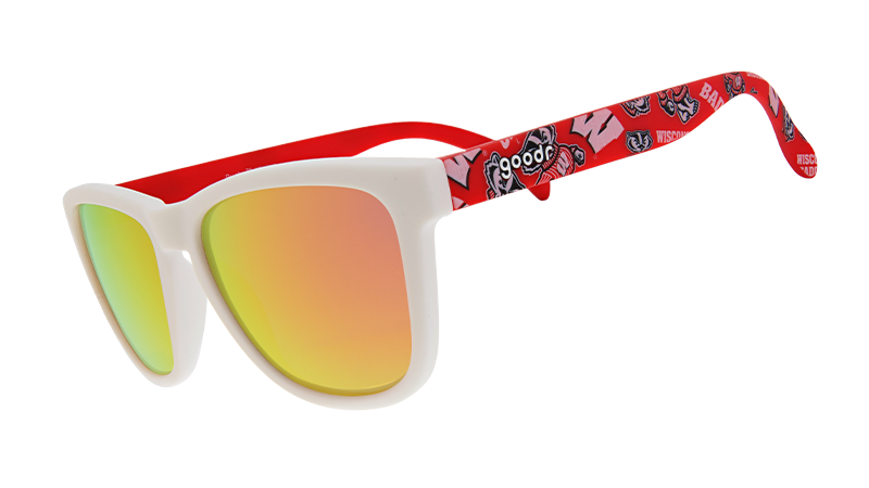 A pair of "goodr" sunglasses with white frames and reflective orange-gold lenses. The arms of the sunglasses are red and feature the University of Wisconsin’s mascot, Bucky Badger, along with bold "W" logos and other school-themed graphics.