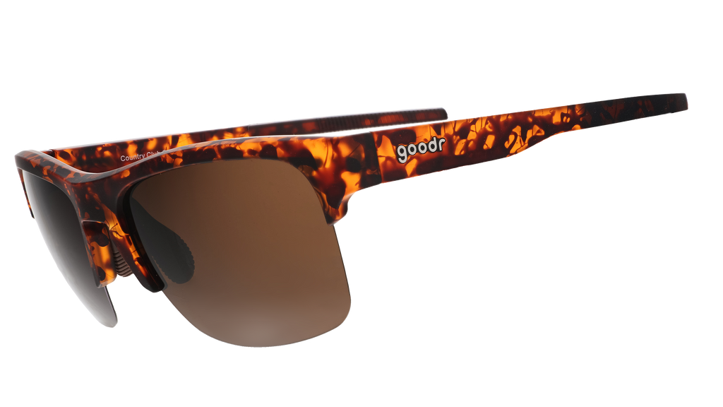 Three-quarter angle view of half-rim brown tortoiseshell sunglasses with brown non-reflective lenses and brown silicone grips on the inner arms.