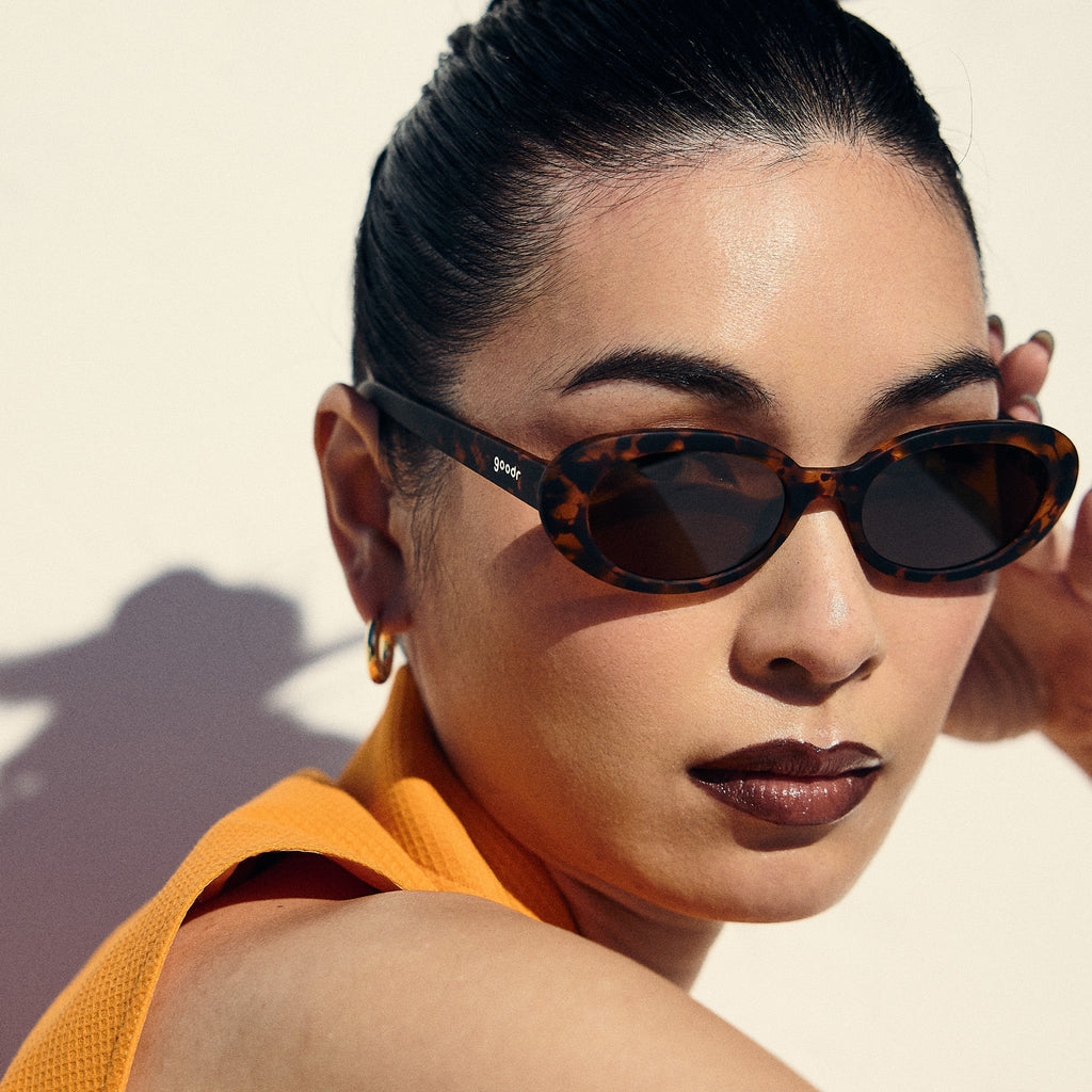 Portrait of a woman with a sleek bun wearing val tortoiseshell sunglasses with brown polarized lenses.