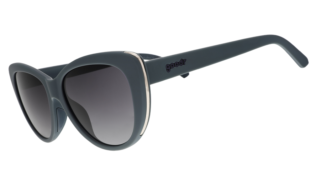 A pair of grey cat eye sunglasses with dark lenses and gold accents on the sides of each frame.