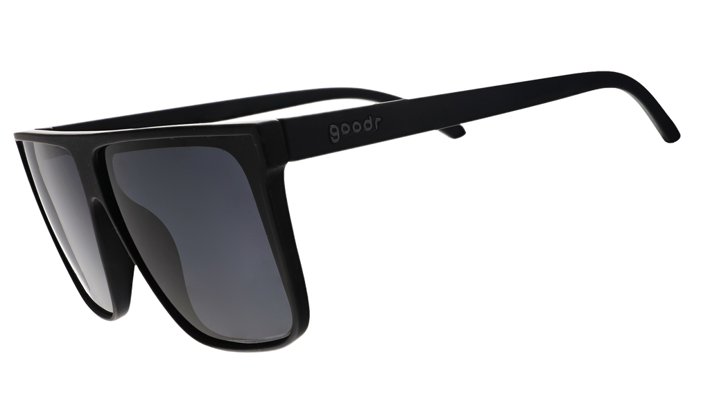 Three-quarter view of black wide-fit, oversized flat-top sunglasses with black non-reflective lenses.