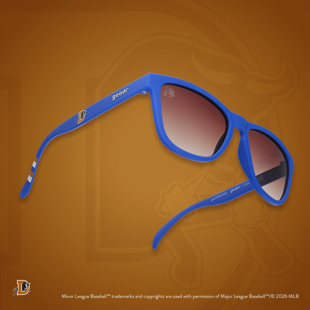 Three-quarter angle view of shades tilted up. Blue frames w/ stripe pattern+Bulls logo on temples+brown gradient lenses.