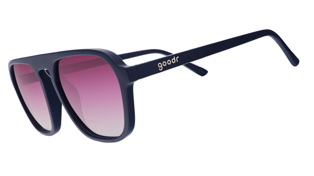 A pair of dark blue goodr sunglasses with gradient pink lenses, on a white background.
