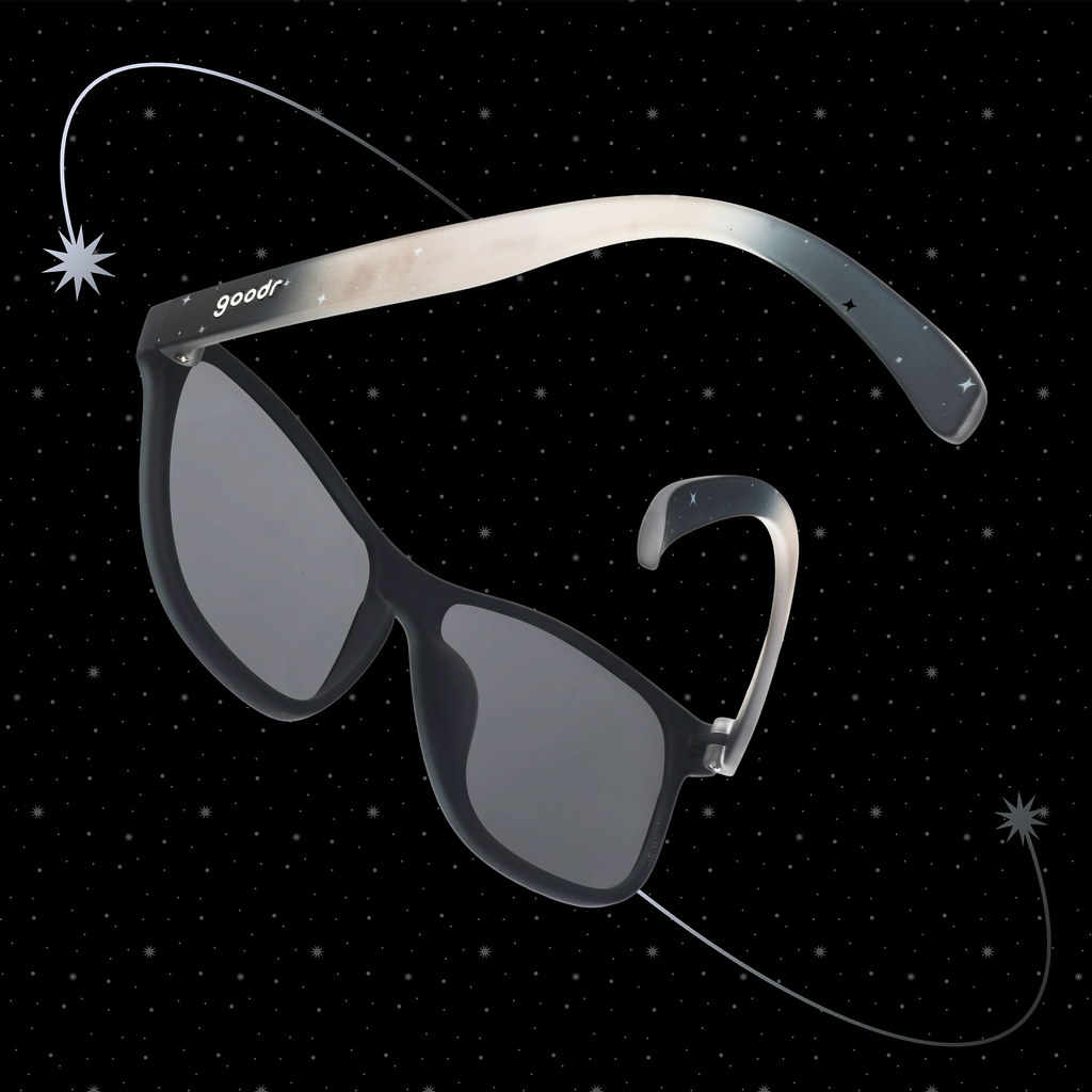 Translucent black-gray ombre VRG frames featuring a cosmos design, photographed from behind with a starry black background.