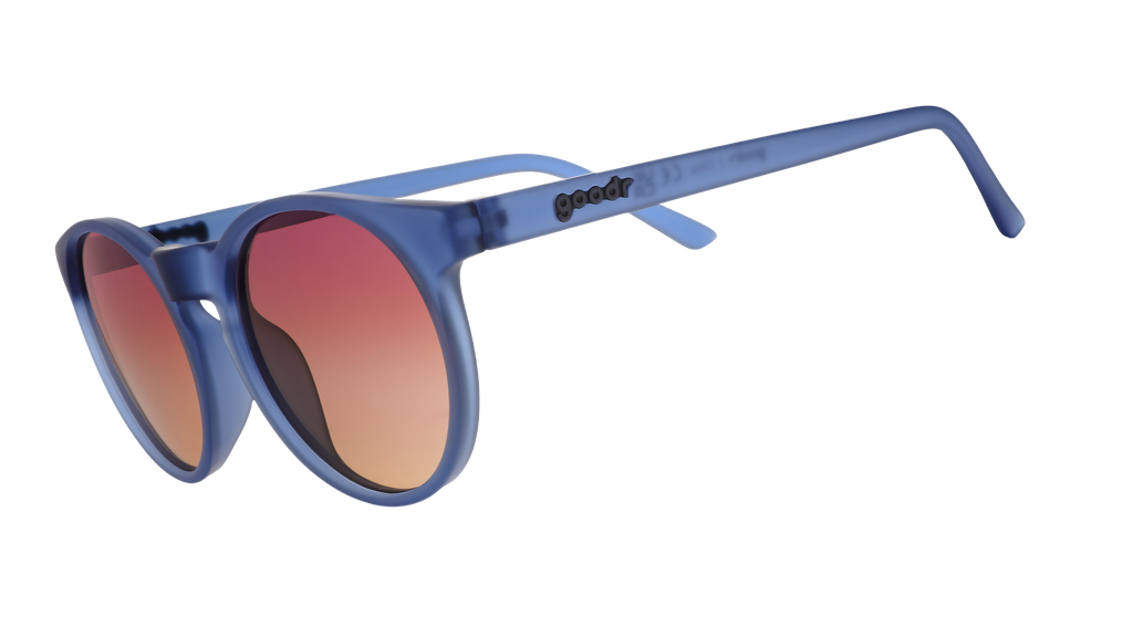 Three-quarter angle view of dark blue circular sunglasses with purple-yellow ocean lenses.