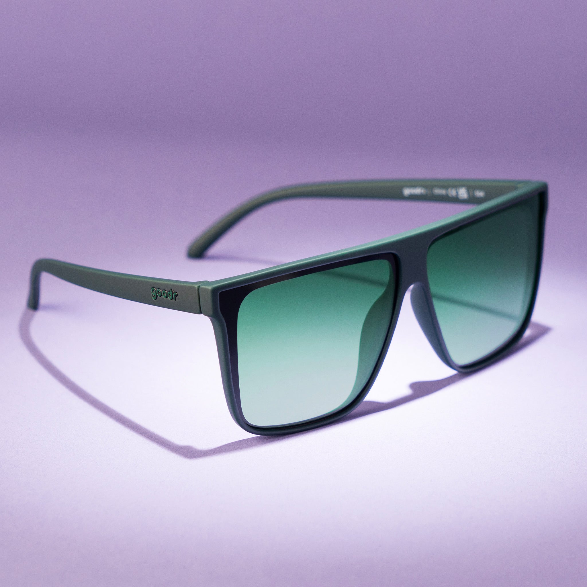 Three-quarter angle view of deep green oversized flat-top sunglasses with green gradient lenses.