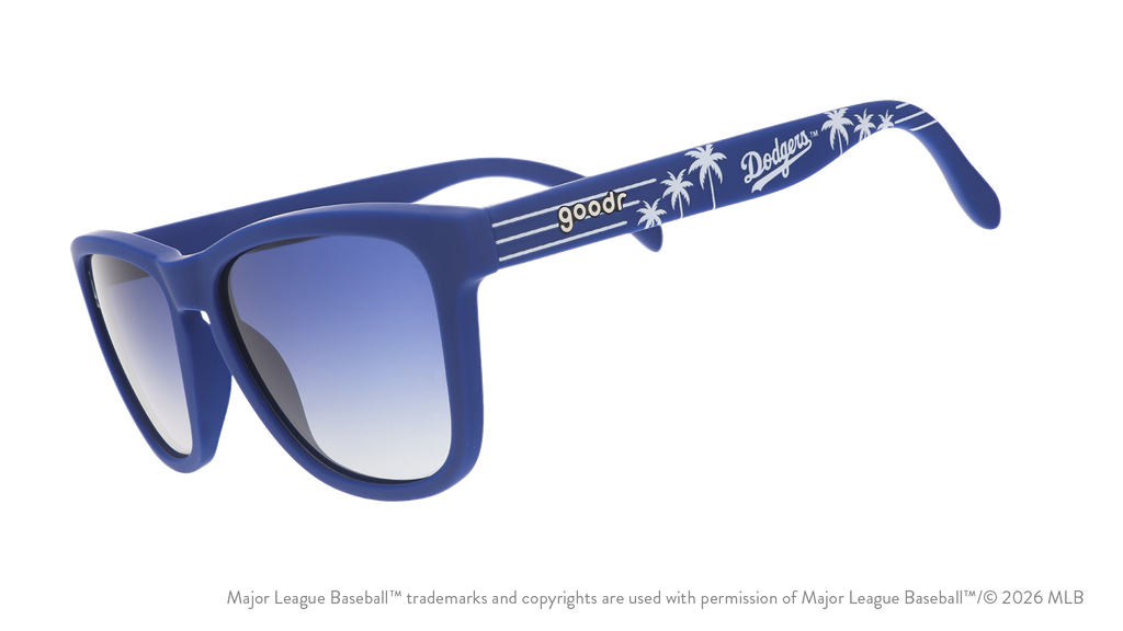 Three-quarter angle view of blue and white Dodgers sunglasses featuring the LA logo and palm trees on the arm.