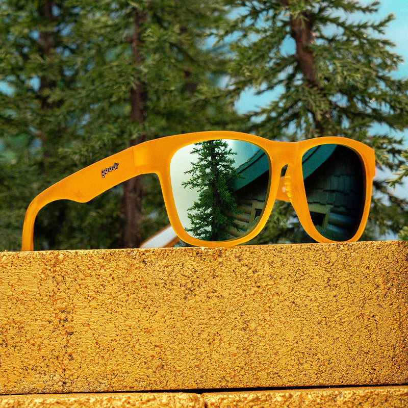 A pair of golden yellow sunglasses with reflective lenses.