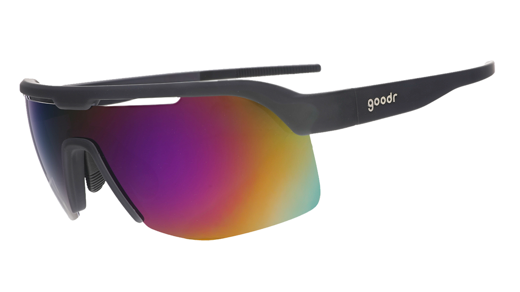 Three-quarter angle view of black shield sunnies with purple reflective wrap lenses tilted down on a white background.