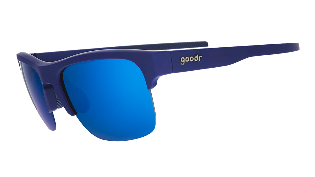 Three-quarter angle view of navy blue sunnies with half-rim frames+blue gradient lenses on a white background.