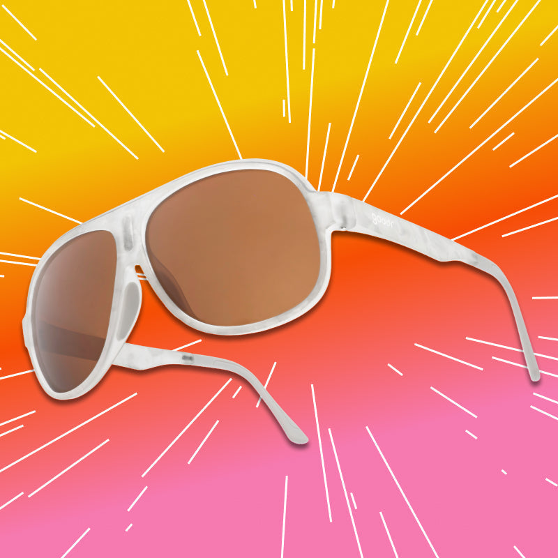 Close-up of aviator sunglasses with a translucent white frame and brown non-reflective lenses.